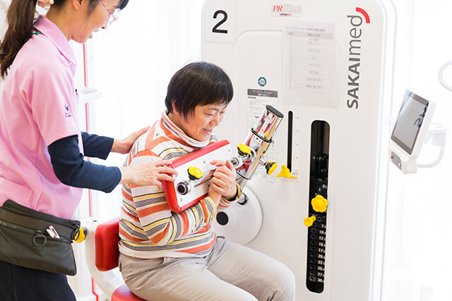 トレーニングマシンを使用している患者の写真